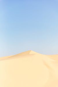 Sand dunes in desert against clear sky