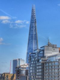 Low angle view of modern buildings against blue sky