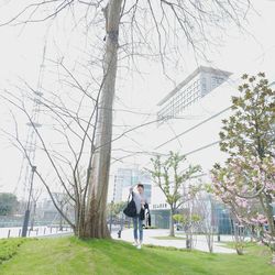 Man standing by tree against sky