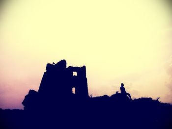 Low angle view of silhouette building against sky