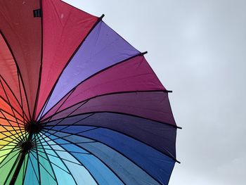 Low angle view of multi colored umbrella against sky, lgbt
