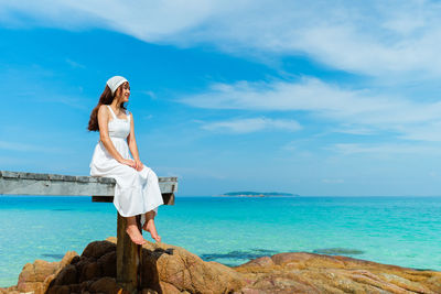 Woman standing by sea against sky