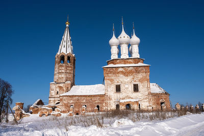 Historic building against clear blue sky during winter