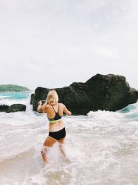 Full length of woman on beach against sky