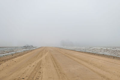 Scenic view of road against sky during winter