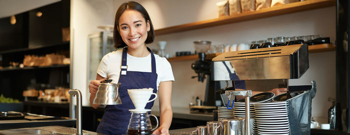 Portrait of young woman standing in cafe