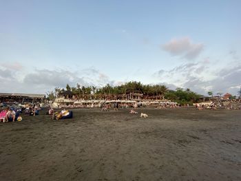 Group of people on beach against sky