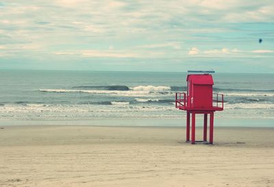 Lifeguard hut on beach against sky