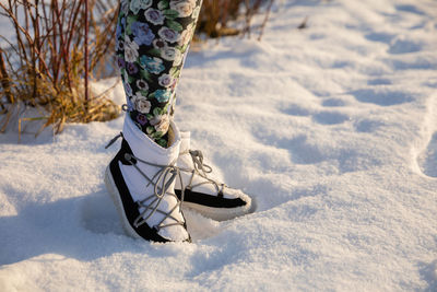 Low section of woman standing on snow