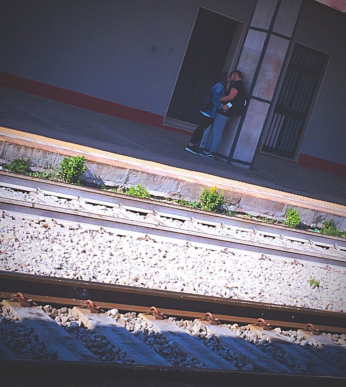 MAN STANDING ON RAILROAD TRACKS