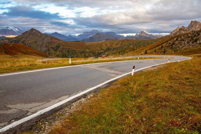 Road leading towards mountains against sky