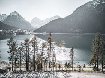 Scenic view of lake by snowcapped mountains against sky