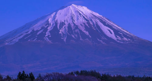 Low angle view of snow covered mountain against clear sky