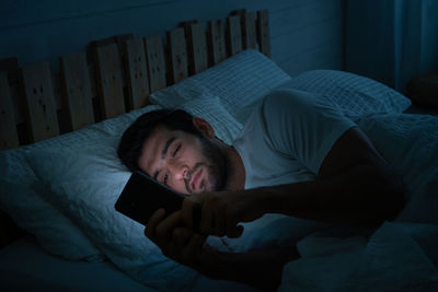 Young man lying on bed at home