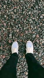 Low section of person standing on pebbles