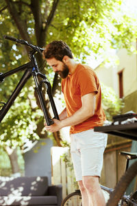 Side view of young man standing in park