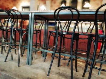 Empty chairs and tables at sidewalk cafe