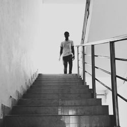 Rear view of boy walking on stairs