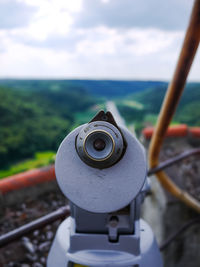 Close-up of coin-operated binoculars by sea against sky