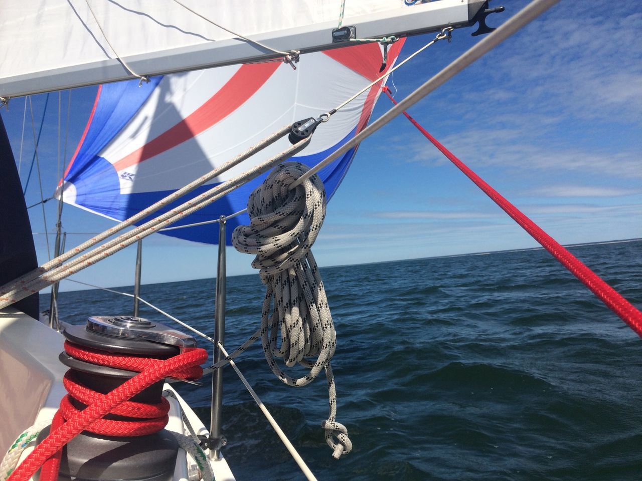 nautical vessel, water, boat, rope, sea, flag, sky, transportation, sailboat, patriotism, mode of transport, day, mast, waterfront, national flag, identity, outdoors, sailing, blue, hanging