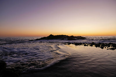 Scenic view of sea against clear sky during sunset