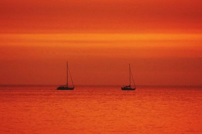 Boat sailing in sea at sunset