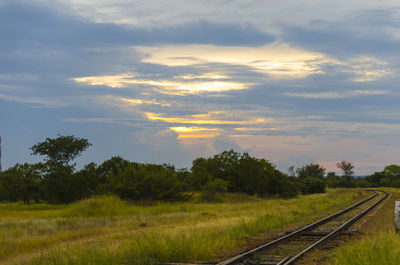 Railway tracks on landscape against sky