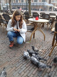 Full length of woman sitting outdoors