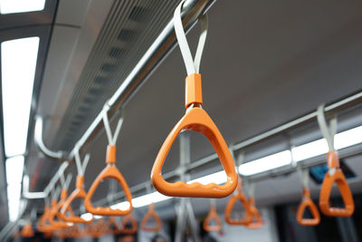 Orange handles hanging in train