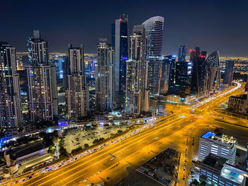 High angle view of illuminated city street and buildings at night