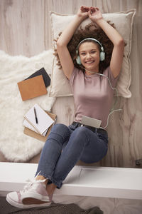 Full length of smiling young woman using mobile phone