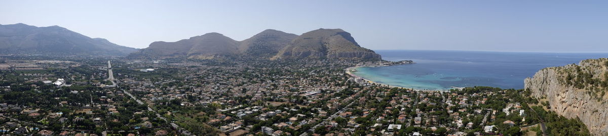 Panoramic view of sea and mountains against clear sky