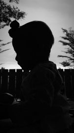 Silhouette boy standing against sky