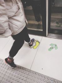 Low section of woman standing on tiled floor