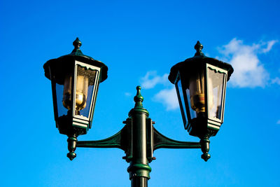 Low angle view of street light against blue sky