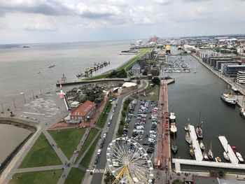 High angle view of city by sea against sky