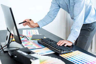 Midsection of businessman working on table