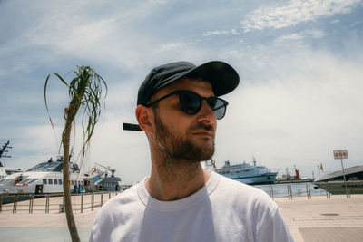 Portrait of young man wearing sunglasses against sky