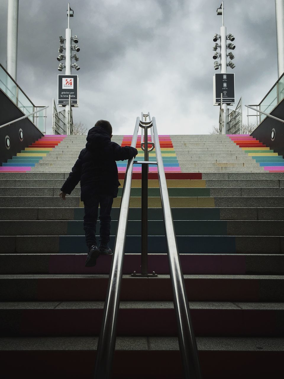 full length, lifestyles, men, rear view, leisure activity, railing, steps, sky, standing, casual clothing, built structure, steps and staircases, cloud - sky, staircase, low angle view, walking, architecture