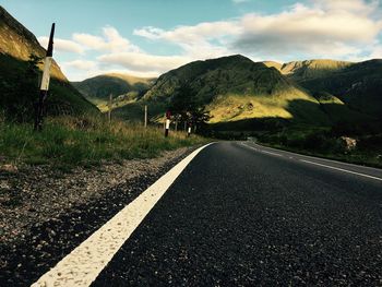 Road amidst mountains against sky