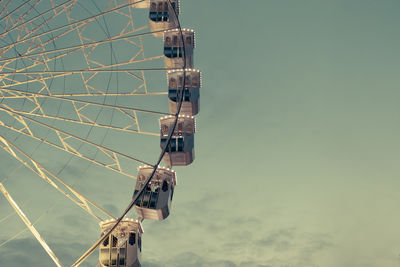 Low angle view of illuminated ferris wheel against sky at dusk