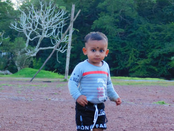 Cute boy standing on field