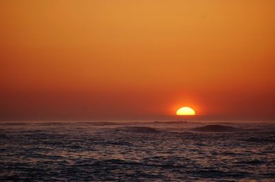 Scenic view of sea against orange sky