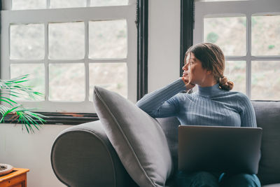 Young woman using laptop at home