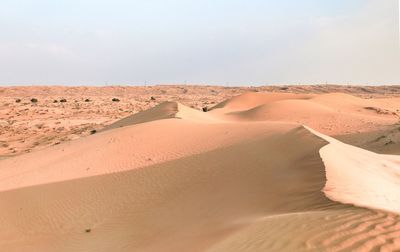 Sand dunes in desert against sky