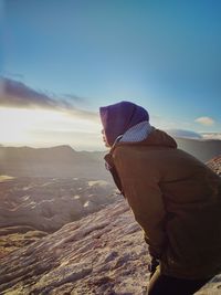 Rear view of man looking at mountain against sky