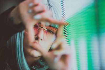 Portrait of young woman gesturing while standing against abstract backgrounds