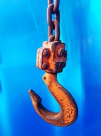 Close-up of rusty chain against blue sky