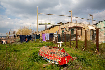 Clothes drying on clothesline on field against sky