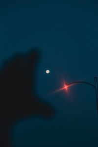 Low angle view of silhouette man standing against sky at night